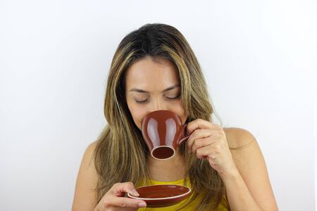 Beautiful Colombian woman drinking a hot coffeeの写真素材
