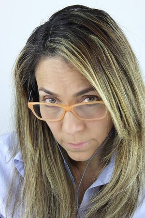 Beautiful business woman looking over her reading glassesの写真素材