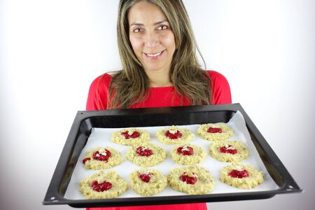 Beautiful woman with a tray of cookies ready for the ovenの写真素材