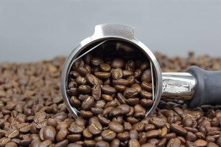 Group handle full of dark roasted coffee beansの写真素材