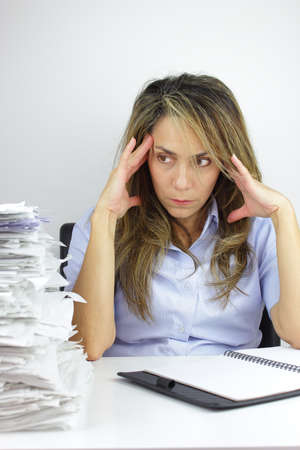 Business woman with a headache at all the paper workの写真素材