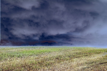 Impressive bad weather in the field. Lead clouds over the earth.の写真素材