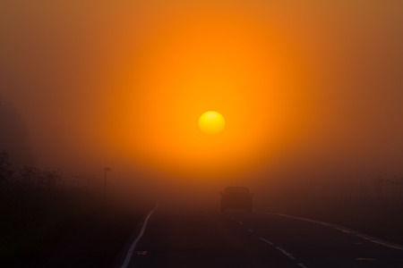 the car at sunrise on the roadの写真素材