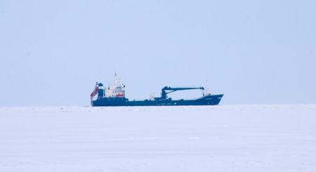 cargo ship moves on a waterway in the winter