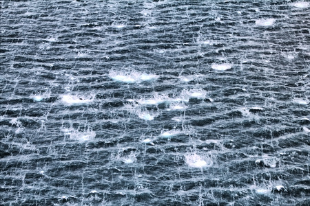 Wave and sea foam, which seems a vertical spray. Drifting ice. View from the top.の写真素材