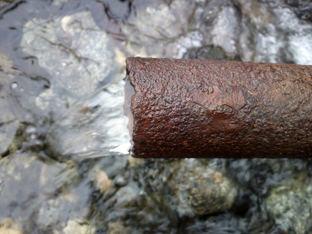 pipe tap nasty rusty with running waterの写真素材