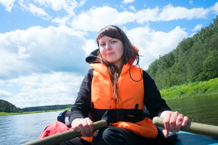 girl in bright rescue clothes on backdrop of vastness of nature and riverの写真素材