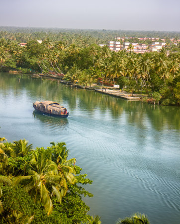 India, Kerala - January 10, 2016: backwaters, India. Tropical landscape. Channels with ships (famous Waterhouse) and towns under palm treesのeditorial素材