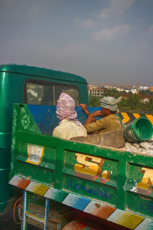 India, near Bangalore - January 26, 2016: Workers riding in back of loaded truck. In poor and developing countries safety (accident prevention) is missing or neglectedのeditorial素材