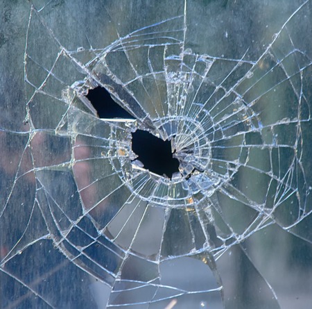 background broken window during riots. glass pieces hole mayhemの写真素材
