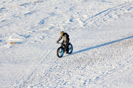 Russia, Zelenogorsk - Nov 12, 2016: cyclist on a fat bike rides along frozen winter sea on beachのeditorial素材