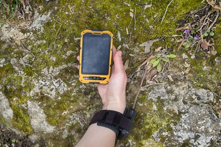 smartphone is ip68 protected in forest background. girl journey in woodland