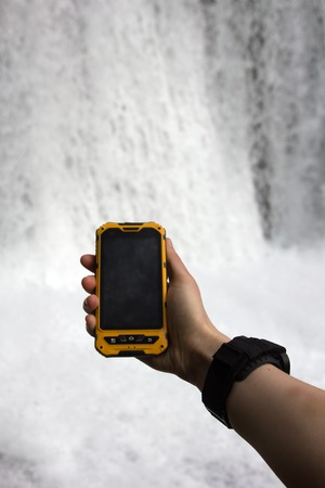 smartphone tracking travel on mountain trails. Phone in hand in a natural walkingの写真素材