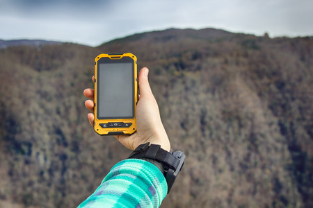 smartphone tracking travel on mountain trails. Phone in hand in a natural walkingの写真素材