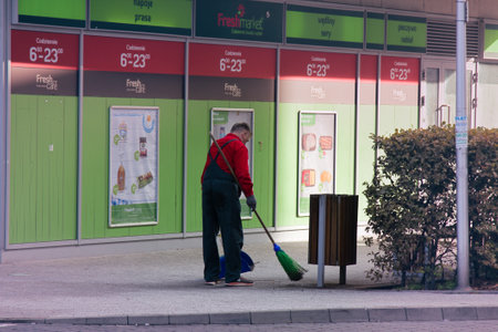 Warsaw, Poland - September 8, 2017: morning job is janitor (sanitation worker) at supermarket, sweep...