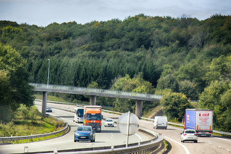 Mulhouse, France - September 15, 2017: Freeway with six lanes. Cracks in pavement are filled with...