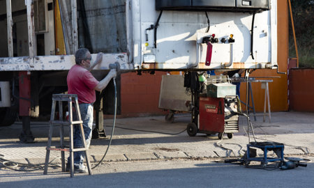 Spain, Girona - October 11, 2017: Repair trailer (truck trailer, cargo trailer) heavy vehicle, cleaning rust, plaster, paint. Car repair shop, technical serviceのeditorial素材