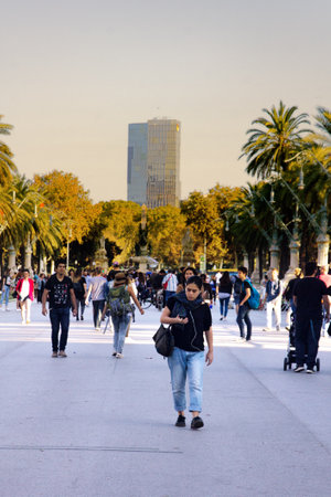 Barcelona, Spain - October 9, 2017: boardwalk, promenade, street, bridge, palm trees, hotels, tourists, citizens. Mediterranean resort and tourist centerのeditorial素材