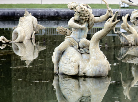 Versailles, France - September 26, 2017: Palace of Versailles, fountains and ponds. Cupids on fish (sea monster) and swans (symbol of marital fidelity), bow boy, love the battleのeditorial素材