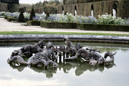 Versailles, France - September 26, 2017: four river nymphs fountain, Naiads. In background sculptural groups and flower beds, green fenceのeditorial素材