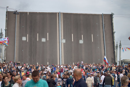 Saint Petersburg, Russia - July 30, 2017: Summer festival Navy. People walk along embankment of river Neva, Divorced for the passage of vessels bridge, nautical flags. wiring river bridgesのeditorial素材