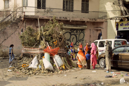 India, new Delhi - March 1, 2018: Indian family is getting ready to celebrate Holly. a huge pile of sticks and debris in the middle of the street night will burn a sacred fireのeditorial素材