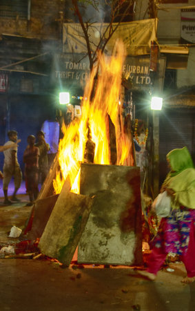India, new Delhi - March 1, 2018: crazy streets of Delhi during Holi celebration. huge bonfires right in the streets. people go close to the fire and heatのeditorial素材