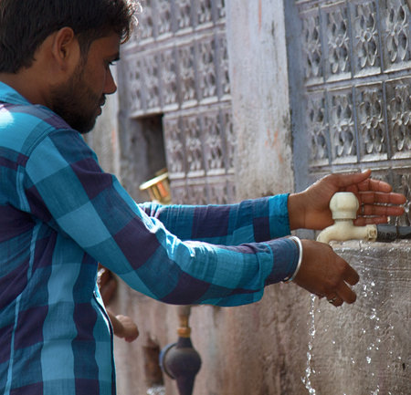 India, Pushkar-March 4, 2018: resident of India washes his hands with clean tap waterのeditorial素材
