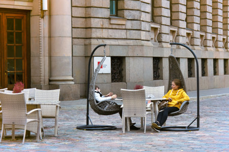 Latvia, Riga - September 4, 2017: young people sitting in a restaurant in the center of Riga on the street.のeditorial素材