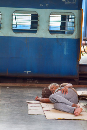 India, Vasco da Gama - 5 April 2018: European in India waiting for train like everyone else, sleeping on floorのeditorial素材