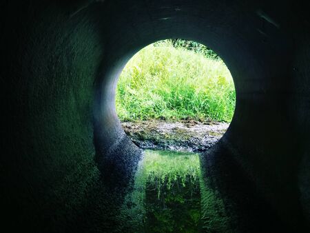 Drainage pipe under the highway (culvert). Filming inside the pipe.の写真素材