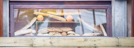 Showcase of small bakery with French bread, rolls and pastriesの写真素材