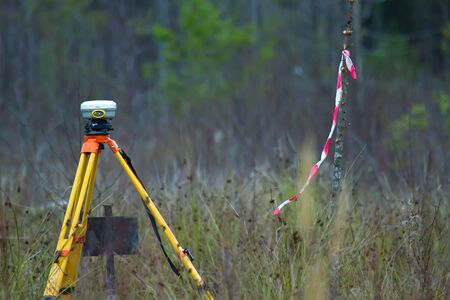 Geodesy as branch of production, land-surveying. GPS receiver geodetic is most perfect (accurate) equipment. Satellite receiver, coordination in conditions of cutting in swampy boreal forestの写真素材