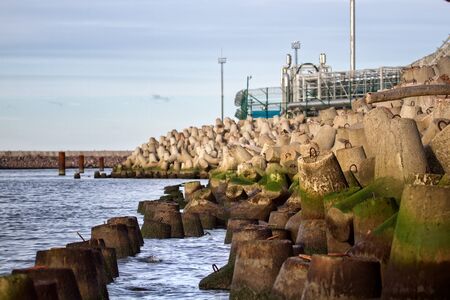 The pipeline goes out to sea, the oil and gas terminal is protected by a tetrapods pierの写真素材