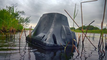 Thrown an old TV floating in river. The era of television at end of daysの写真素材