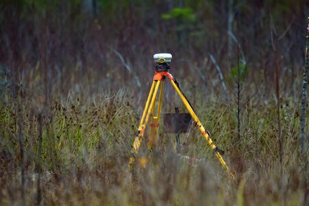 Geodesy as branch of production, land-surveying. GPS receiver geodetic is most perfect (accurate) equipment. This device is supplied as basic receiver in conditions of cutting in swampy boreal forestの写真素材