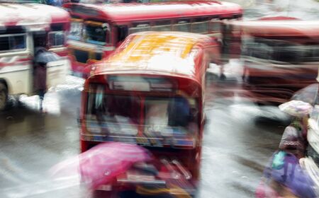 Blur night bus in rainy weather in Southeast Asia. A bunch of buses in motion at bus stationの写真素材