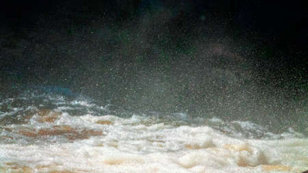 Water backgrounds with foam spray fast flow. The water in mad flows with droplets and whirlpools of waterfalls.の写真素材