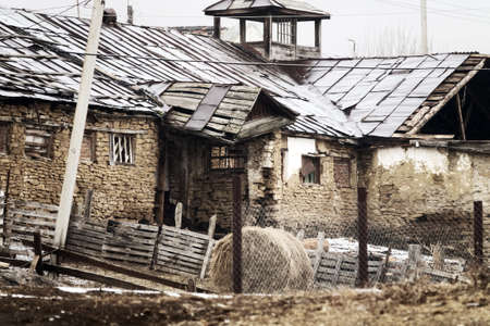 Dying mountain villages (aul) in the Caucasus. Dilapidated houses in winter. Poor farmsの写真素材