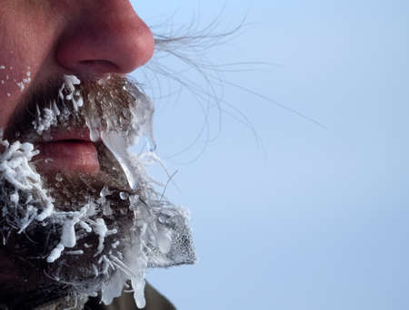 Extremely severe frosts cover people with icicles. Cold weather and climate change in winter. Person suffers from hypothermia. Unusually harsh winter in february. Body parts of anonymous personの写真素材