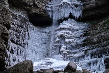 Waterfall in winter. Water jets freeze and icicles form. Attractive ice shapes and white frost - like a theater stage and impressive winter setsの写真素材