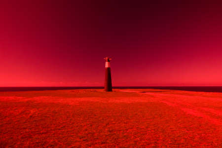 An ancient lighthouse on edge of a cliff. The magic and beauty of the sea. Surrealistic art infrared...