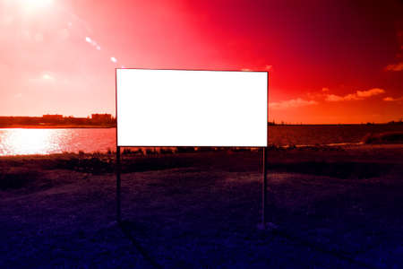 Pure white public board on clogged shore of lake and against background of village. It is clear without words (or write your own expression), dumb question - until when to pollute nature.の写真素材