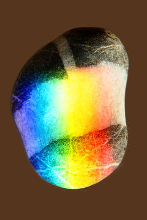 Zen stone in touch of rays of color. The concept of maximum joy from colorの写真素材