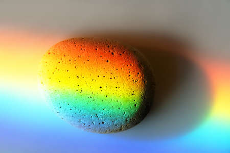 Zen stone in touch of rays of color. The concept of maximum joy from colorの写真素材