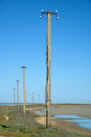 Concrete erosion (weathering of concrete). This collapsing iron-concrete electrical wiring pole stands on a windy and frosty seashore. Probable age 40-50 yearsの写真素材