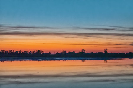 Aurora sunrise view of the old piscatory settlement and calm salty lagoon. There are no fish now, the village is empty, wasteland, a sleepy kingdom. Arabatskaya strelka spit, Azov Seaの写真素材