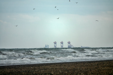 The Arabian Sea and the cranes of the lift ship over the horizon. Oman