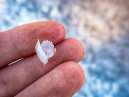 Crystals of self-seeding salt on the shore of a hypersalted lake. A crust of salt on the fingers