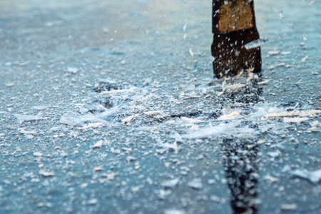 Vintage types of work. A fisherman hammers a hole with an ice chisel. Ancient ice fishing, winter worriesの写真素材